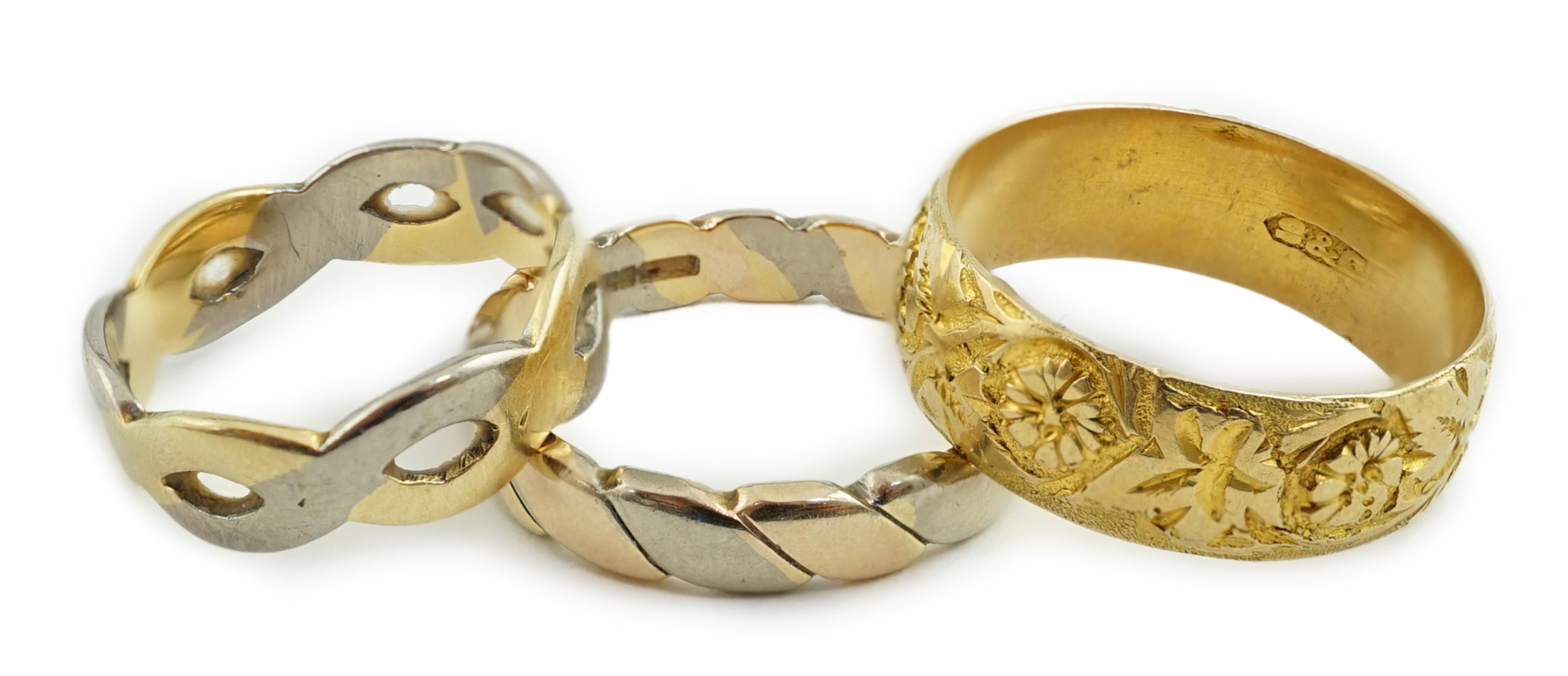 A George V engraved 18ct gold band, size M/N, together with two three or two colour 18ct gold bands